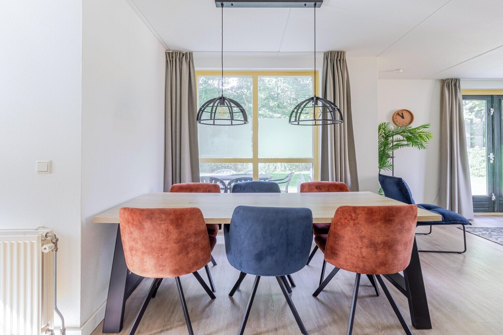 A dining area with a table, chairs, and pendant lights.
