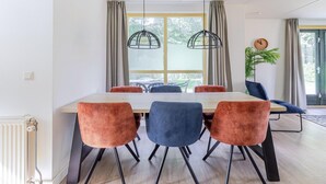 A dining area with a table, chairs, and pendant lights. - Serene Ewijk Abode by the Lake (Ewijk)