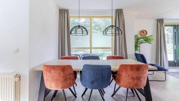 A dining area with a table, chairs, and pendant lights.