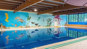 An indoor swimming pool with a mural of marine life, a diving board, and a window with a view of trees. - Serene Ewijk Abode by the Lake (Ewijk)