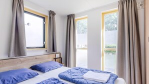 A bedroom with a bed, pillows, a headboard, and curtains. - Serene Ewijk Abode by the Lake (Ewijk)