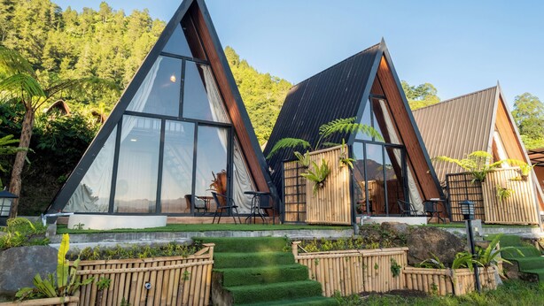 A modern, triangular-shaped building with large windows, a wooden deck, and surrounding greenery. - Royal VIP Glamping Kintamani (Kintamani)