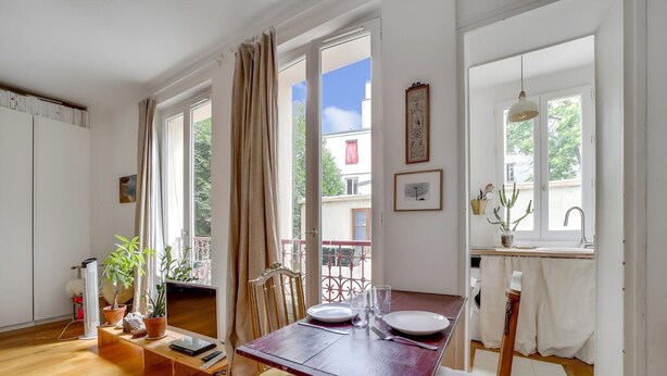 Un espace repas avec une table en bois, des chaises et une vue sur l’extérieur.
