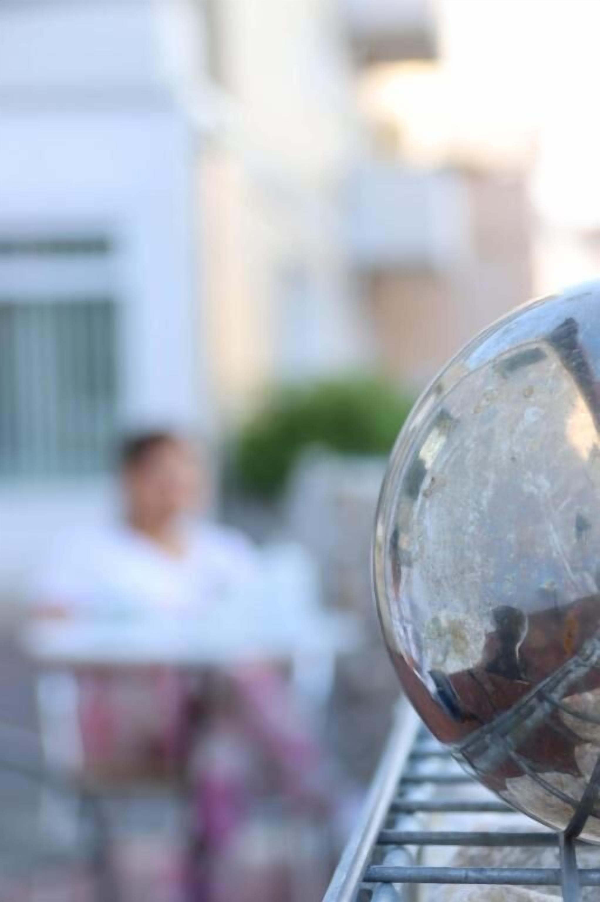 A clear view of a glass object, possibly a window or a mirror, with a blurred background.