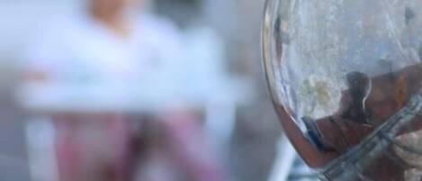 A clear view of a glass object, possibly a window or a mirror, with a blurred background.