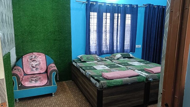 Un dormitorio con cama, una silla y una ventana con cortinas.