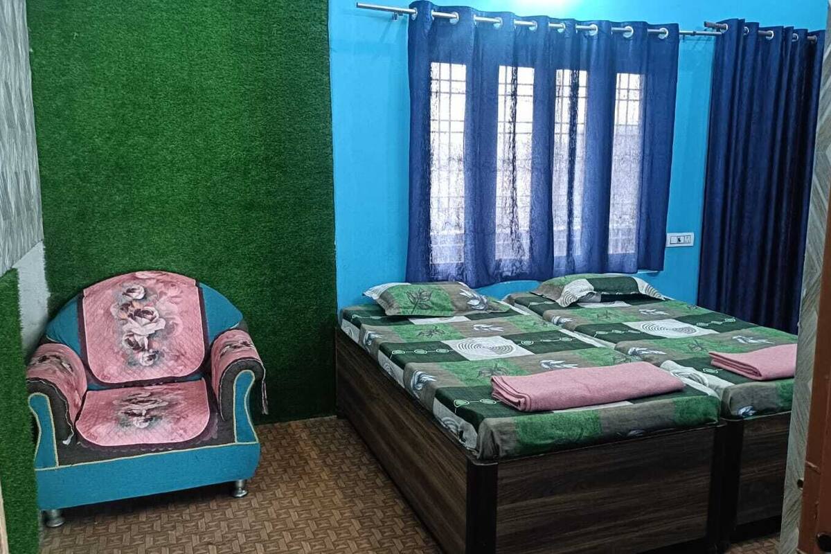 Ein Schlafzimmer mit einem Bett, einem Sessel und einem Fenster mit Vorhängen.