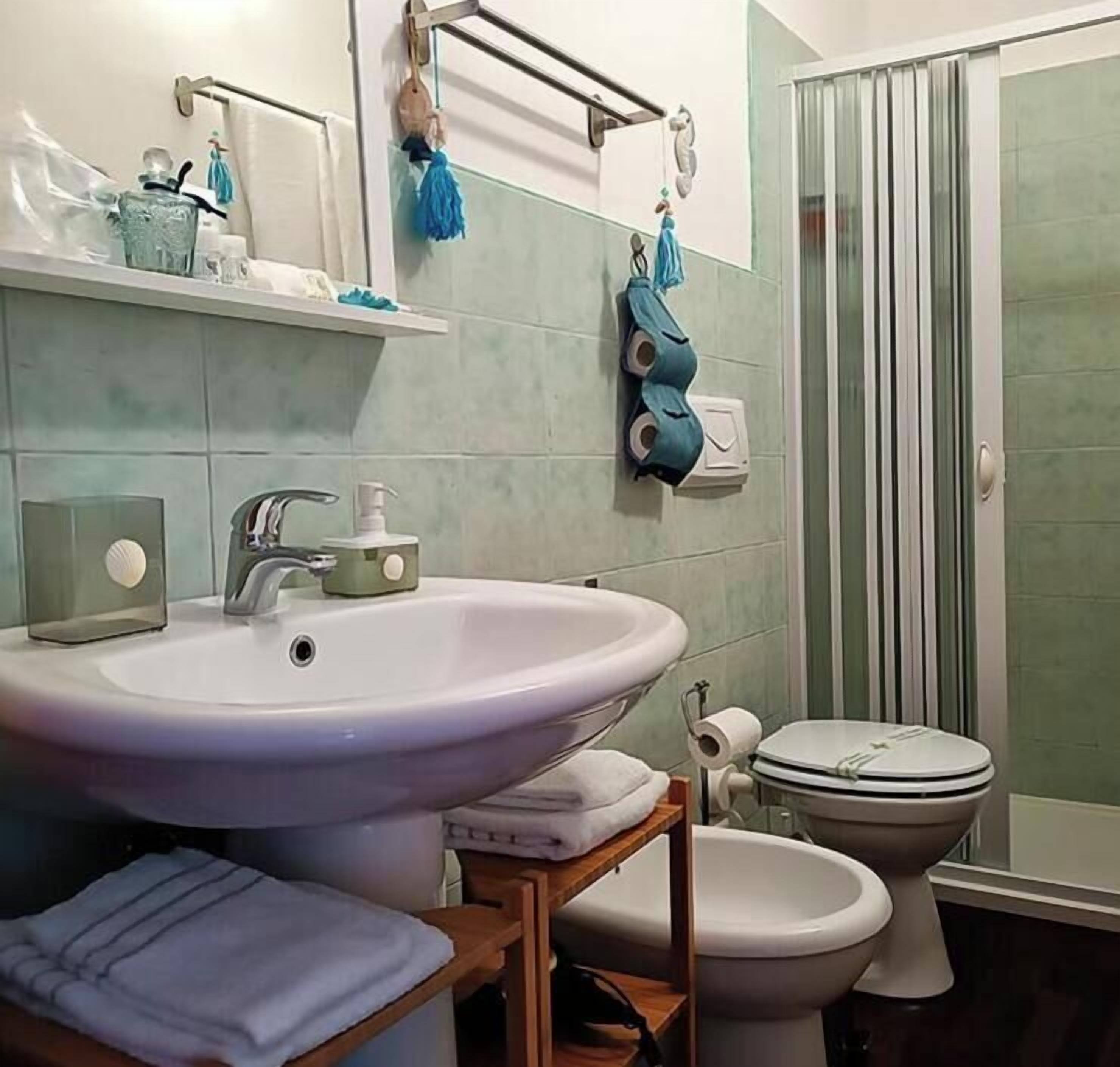 Un baño con lavamanos grande, inodoro y ducha.