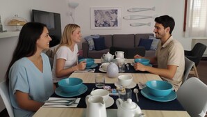 Un comedor con una mesa dispuesta para cuatro personas, que incluye tazones, tazas y una tetera.
