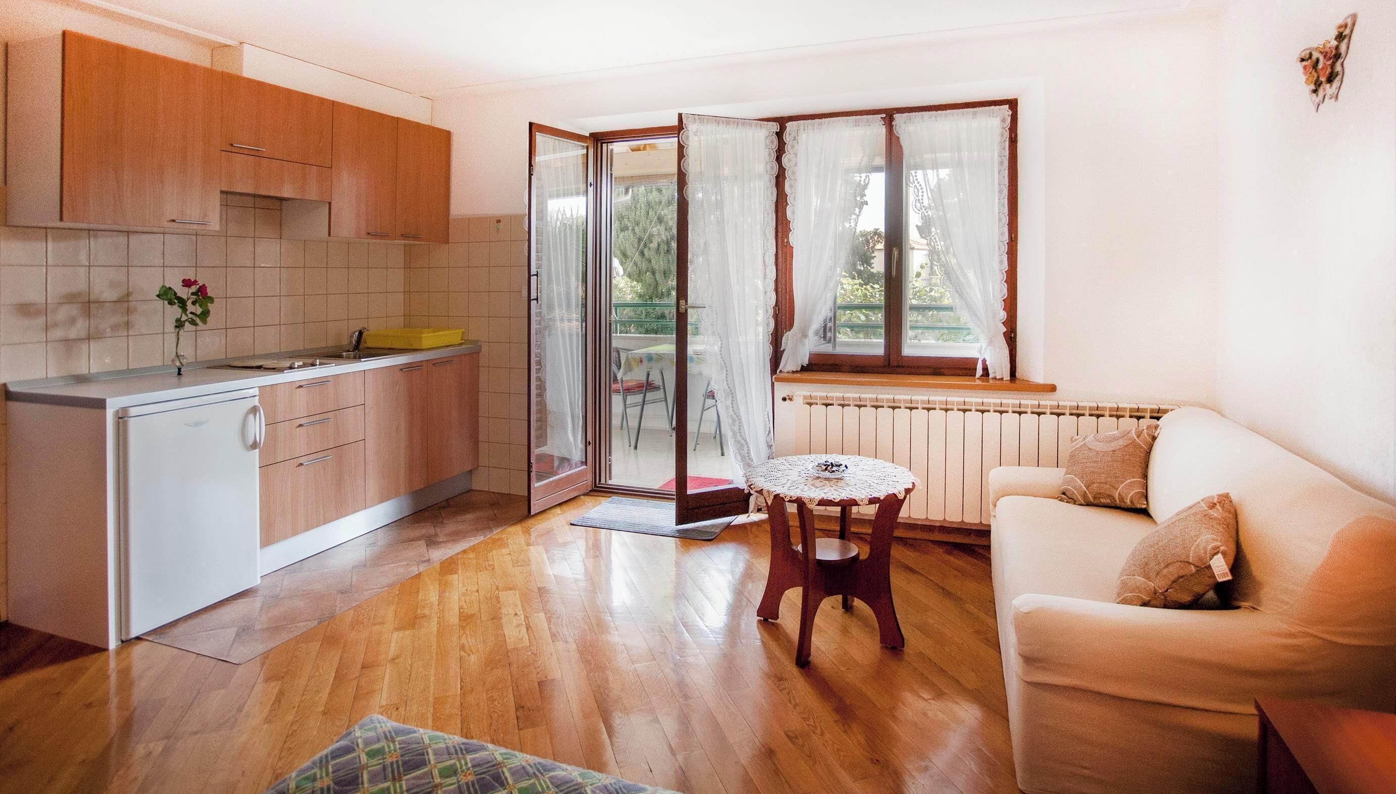 A compact living space with a kitchenette, a dining area, and a seating area with a view.
