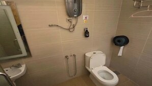Een badkamer met toilet, wastafel, douche en handdroger.