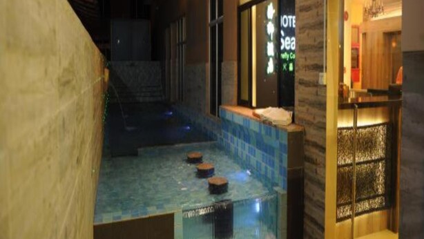 Een hotel met een zwembad, een receptie en een trap naar de ingang.