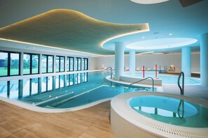 An indoor swimming pool with a hot tub, large windows, and a modern ceiling design. - PINEA RESORT POBIEROWO (Pobierowo)
