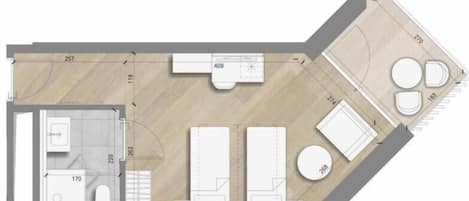 A floor plan of a hotel room with a bathroom, a small kitchen area, a seating area, and a circular seating space.