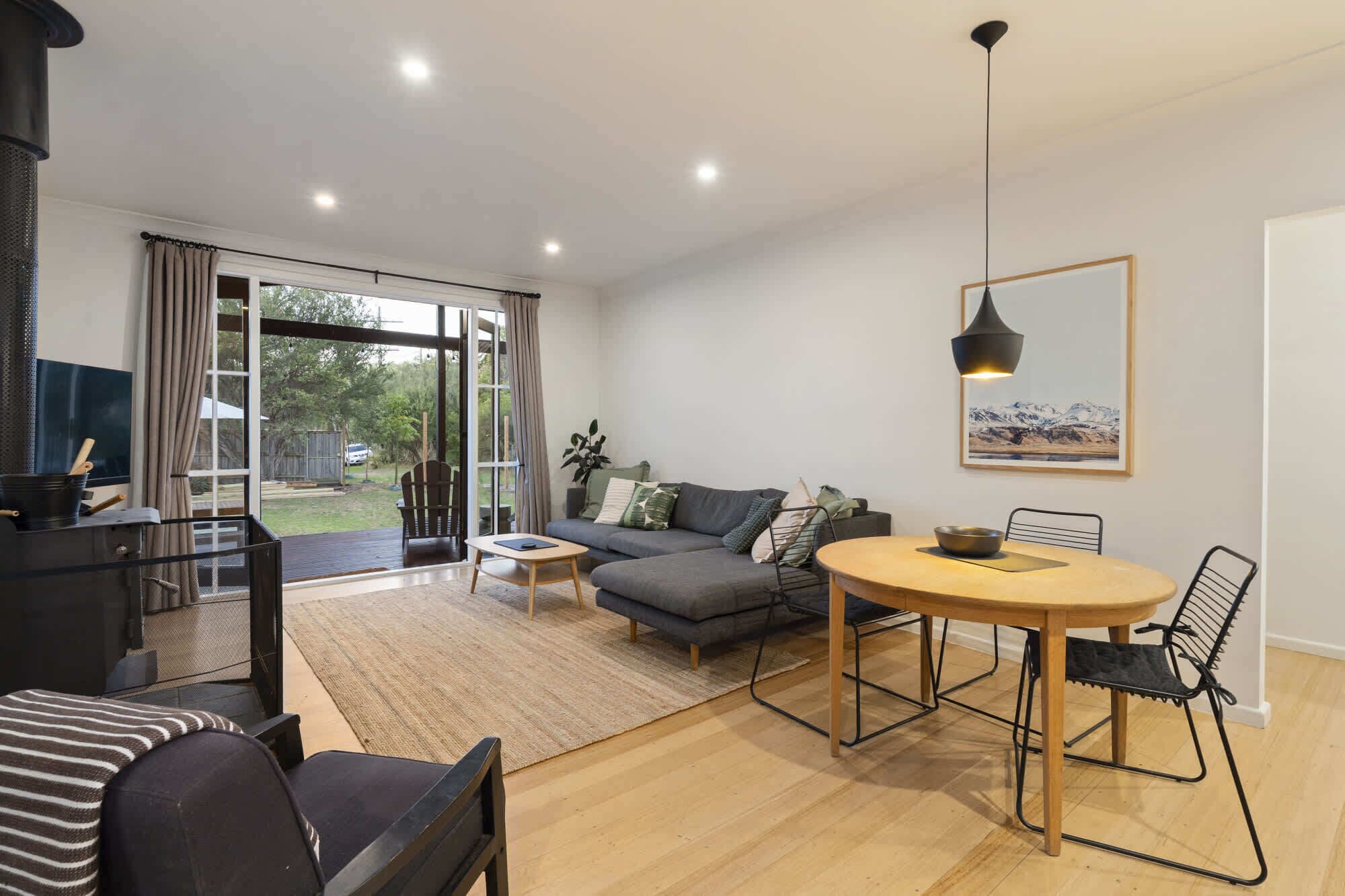 Een moderne woonkamer met een bank, een eettafel en een open haard.