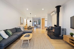 Ein modernes Wohnzimmer mit Sofa, Couchtisch und Kamin.