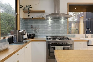 Eine moderne Küche mit Gasherd, Backofen und Blick auf Grünflächen.