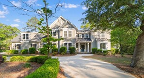 A large, two-story house with a prominent front porch, a driveway, and well-maintained landscaping. - 5 BR 4 BA Home Close To The Marsh Walk (Murrells Inlet)