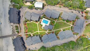 Oversigtsbillede af et boligområde med flere huse, en swimmingpool og en lukket indgang.