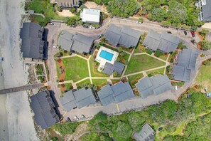 An aerial view of a residential area with multiple houses, a swimming pool, and a gated entrance. - Beach Time Oceanview 3 Bedroom (Pawleys Island)