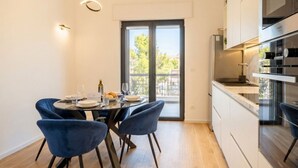 A modern kitchen with a dining area, large windows, and a view of the outdoors. - MareVista - Private Garden & Parking (Bari)