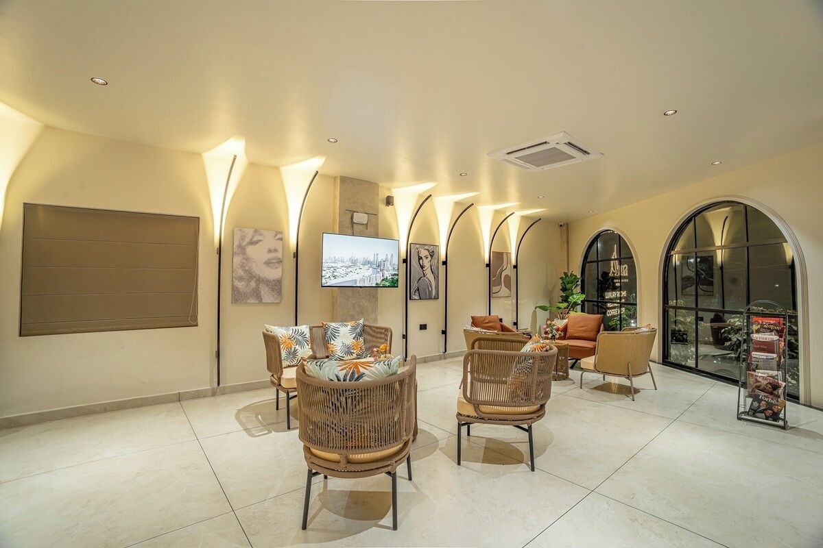 A spacious lobby with wicker furniture, a flat-screen TV, and a coffee station.