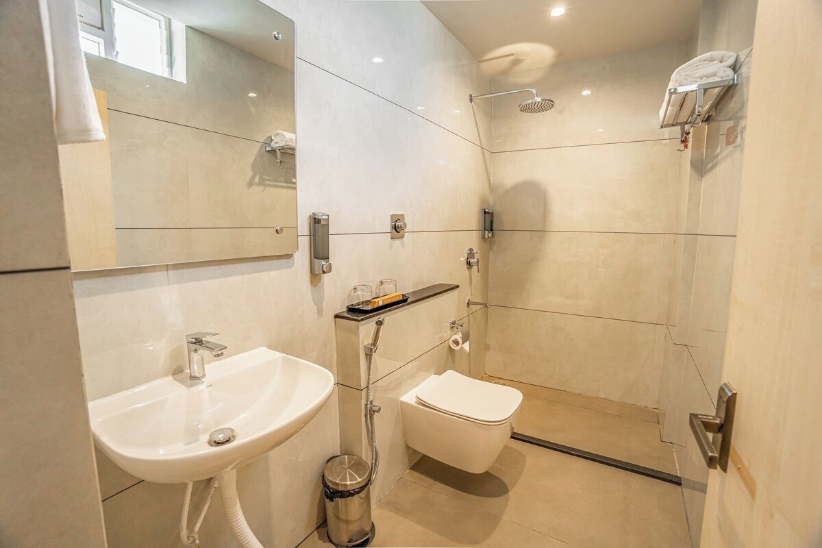 Une salle de bain moderne équipée d’un lavabo, de toilettes et d’une douche.