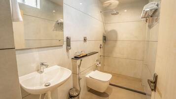 Une salle de bain moderne équipée d’un lavabo, de toilettes et d’une douche.