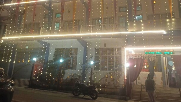 Un edificio de varios pisos con luces y cortinas colgantes.