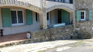 Un edificio in pietra con finestre ad arco e una panchina all'esterno.