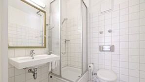 A bathroom with a sink, toilet, shower, and a mirror. - Boardinghouse Rosenheim (Rosenheim)