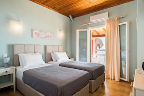 A bedroom with two beds, a nightstand, a wall-mounted light, and a window with curtains. - Baracunda Seaview Apartments with private Hot Tub by Konnect (Corfu)
