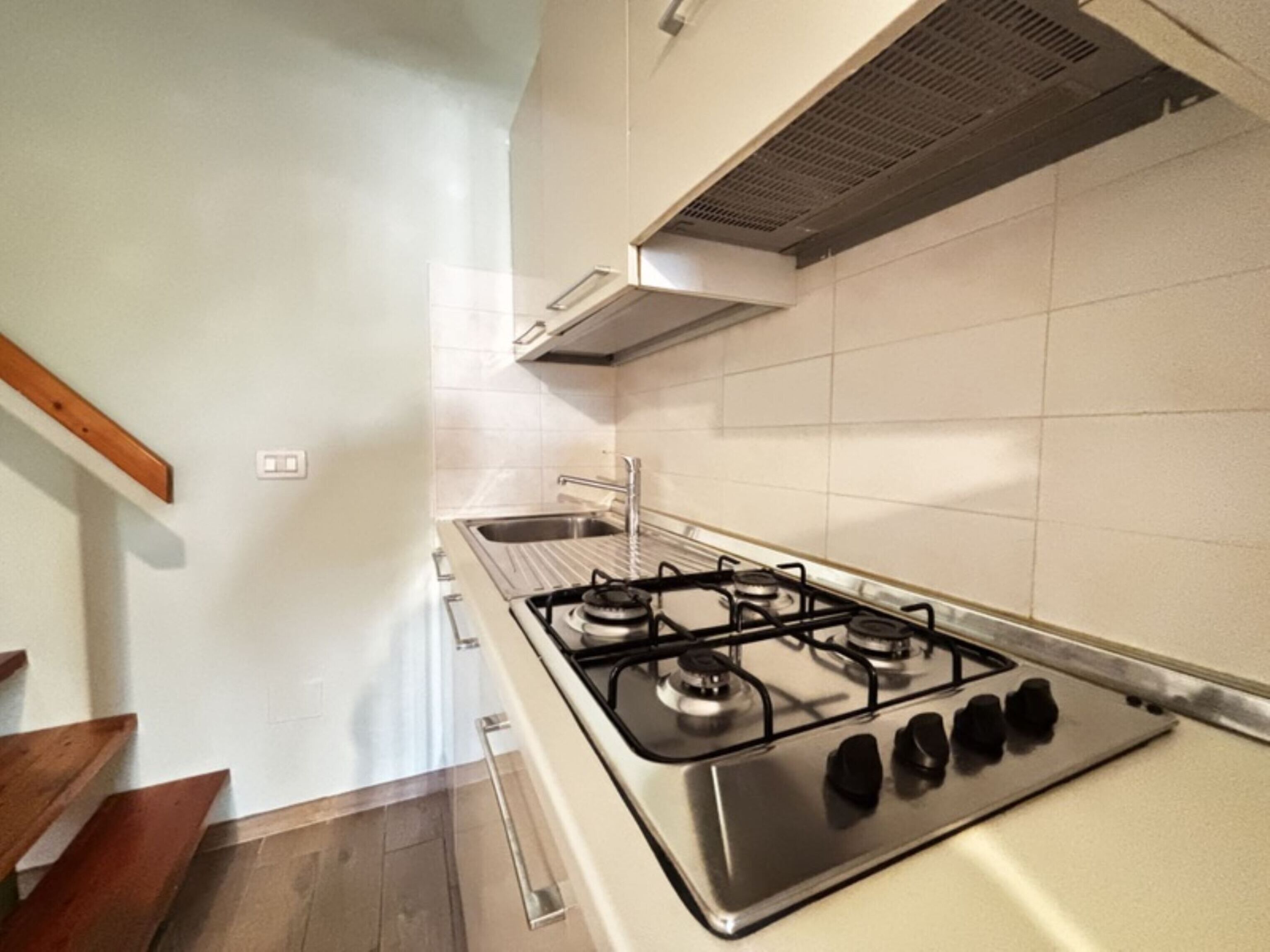 Cuina amb fogó de gas, una barra i una campana d'extracció.