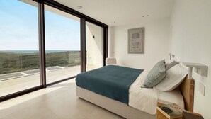 A bedroom with a large window, a bed with pillows, a bedside table, and a wall-mounted light fixture. - Luxury residence with pool - Terra di Bertolino in Menfi - DiCasaInSicilia (Menfi)