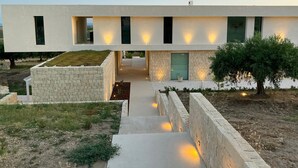 A modern building with a flat roof, a central pathway, and a small garden area. - Luxury residence with pool - Terra di Bertolino in Menfi - DiCasaInSicilia (Menfi)