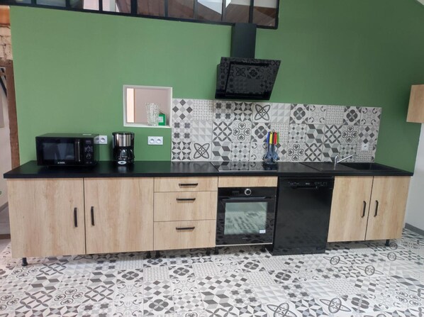 A kitchen with a microwave, coffee maker, and dishwasher.