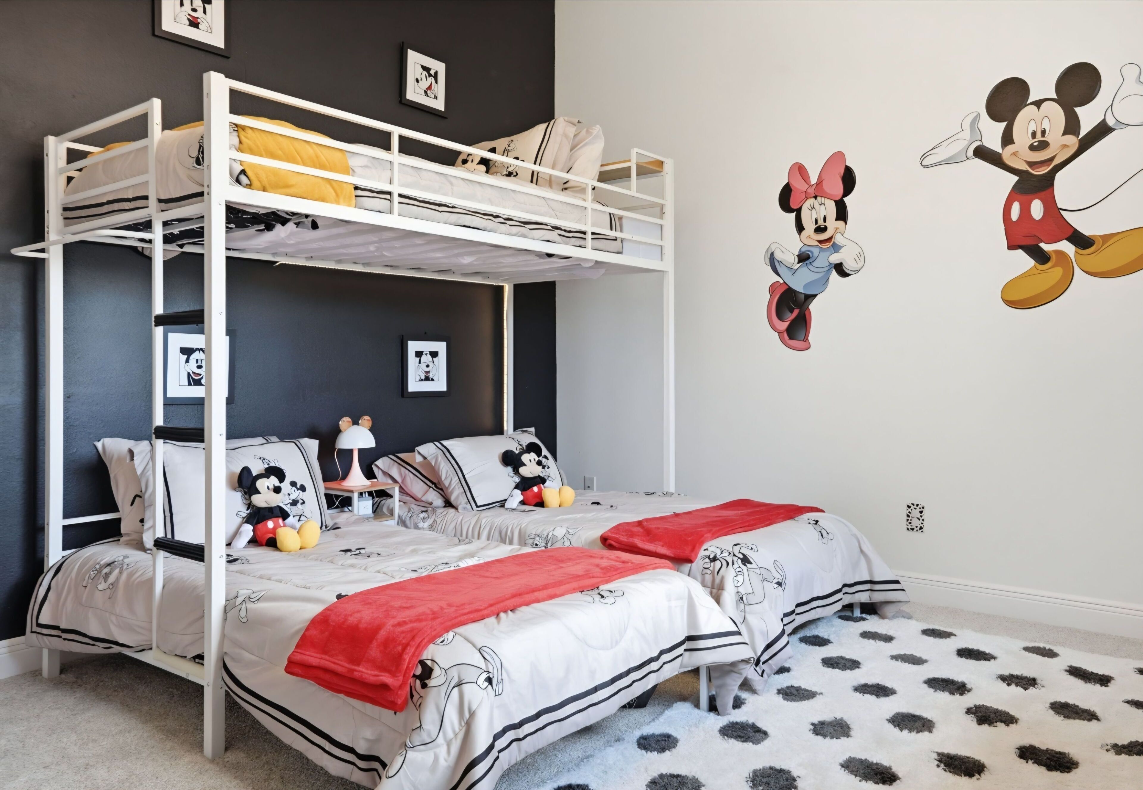 A themed bedroom featuring cartoon character wall decals and white metal bunk beds.