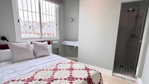 A bedroom with a bed, a window, a shower, and a bathroom. - Alameda Grand Luxury (Seville)