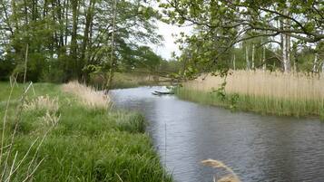 A calm river with surrounding greenery and trees.