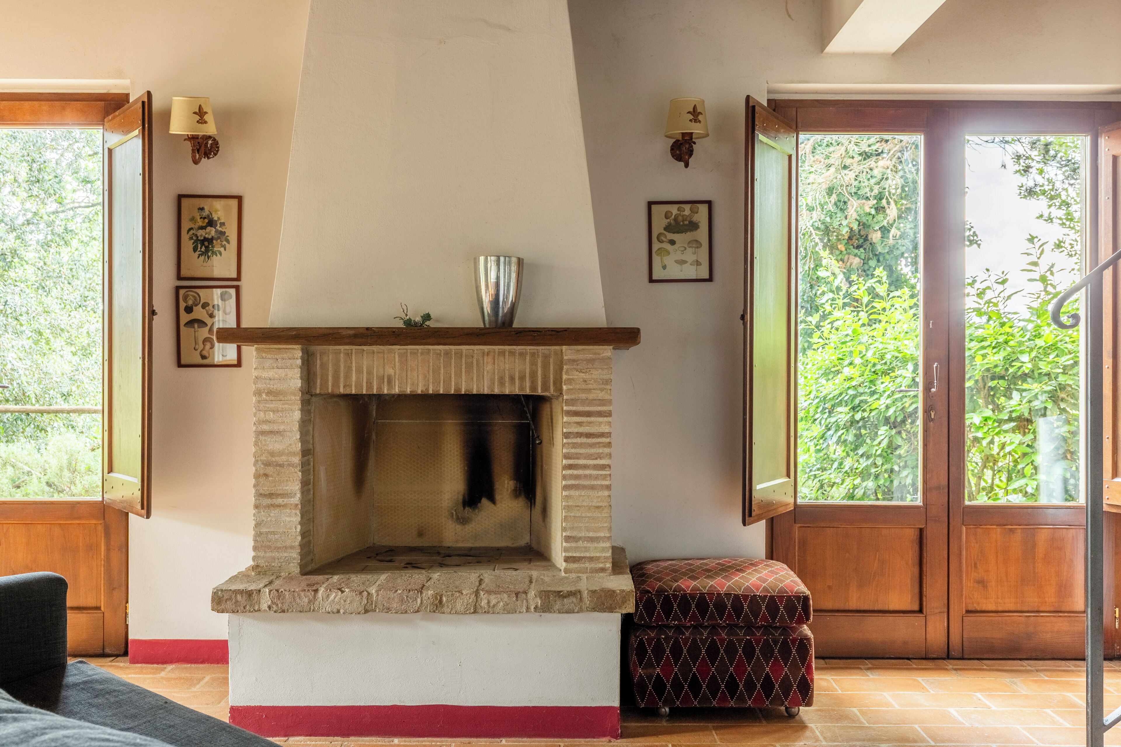 A room with a fireplace, a bench, and a door leading to an outdoor area.