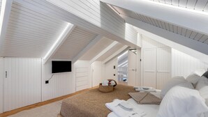 A bedroom with a large bed, a flat-screen TV mounted on the wall, and a wooden ceiling. - Mario Luxury Seafront Penthouse with Jacuzzi – Casa di Mario, Kalyves, Crete (Kalives)