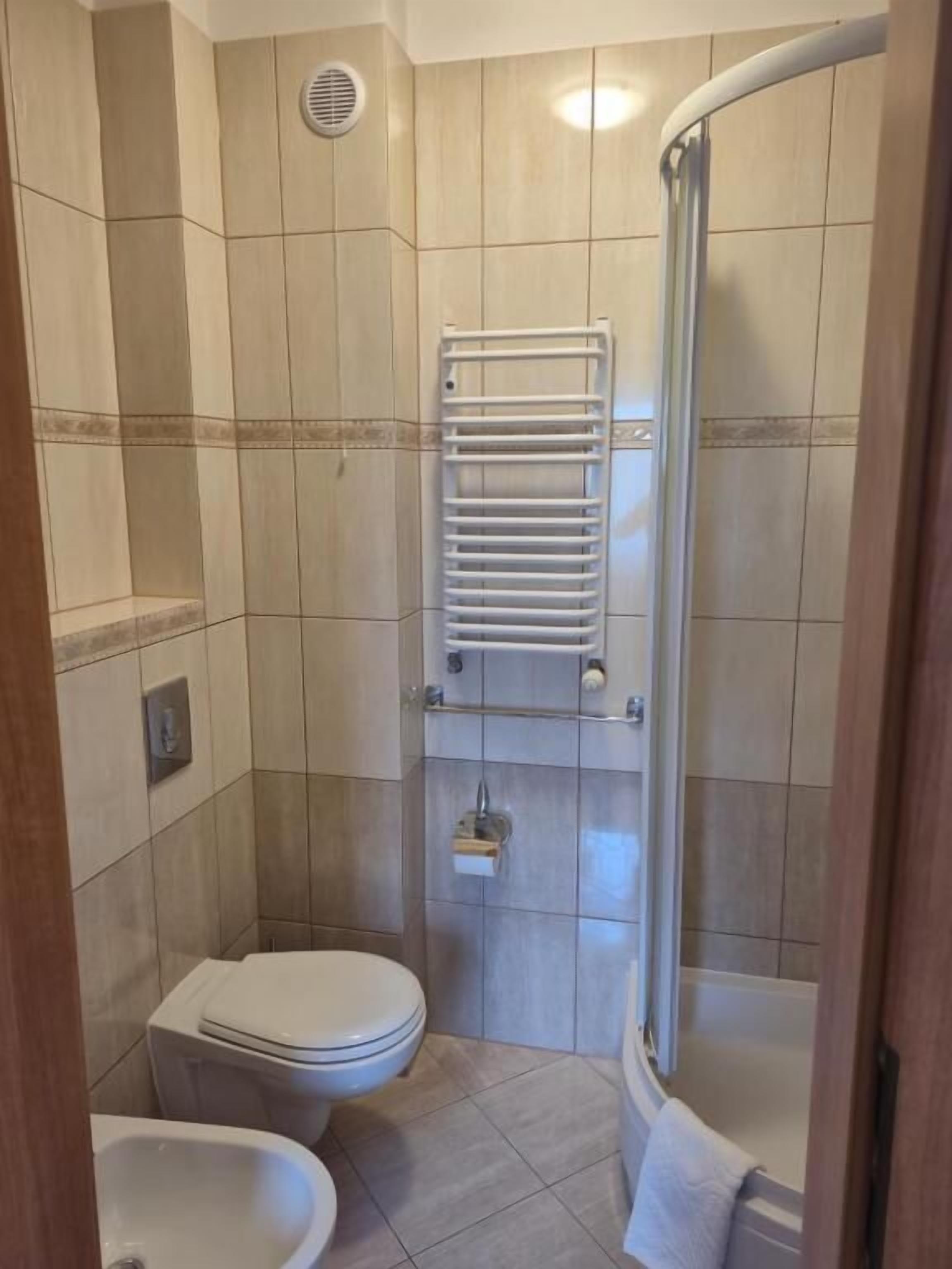 A bathroom with a toilet, bidet, and a shower with a glass door.