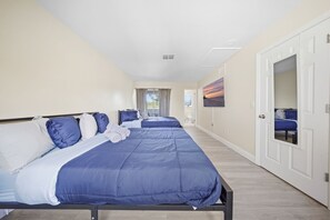 Een hotelkamer met een groot bed, een badkamer en uitzicht op het strand.