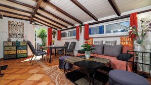 Ein gemütliches Wohnzimmer mit Sofa, Sesseln, einem Couchtisch und einem Essbereich mit Tisch und Stühlen.