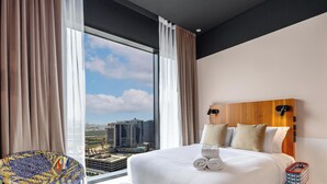 A hotel room with a large bed, a view of buildings, and a cityscape. - LUX | The Five Star Modern Studio (Dubai)