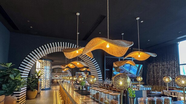 A modern bar area with unique lighting fixtures, a checkered floor, and a large screen displaying a cityscape. - LUX | The Five Star Modern Studio (Dubai)