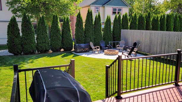 Un jardin avec un foyer, des sièges d’extérieur et un barbecue.
