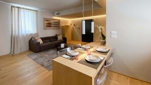 Un salon moderne comprenant un canapé, un coin repas et une petite cuisine.