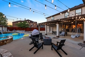 An outdoor patio with a pool, seating, and string lights. - Large Groups' Luxury House Pool Sleep 22 (Round Rock)
