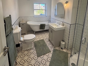 Ein Badezimmer mit Toilette, Badewanne, Waschbecken und Dusche.